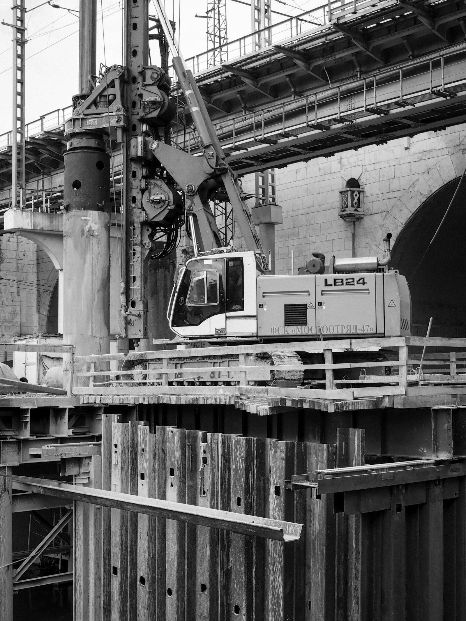 Black-and-white construction site under a bridge